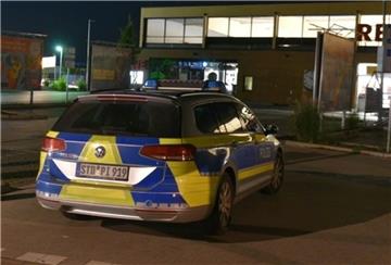 Polizeiauto in der Nacht auf Parkplatz vor Supermarkt.