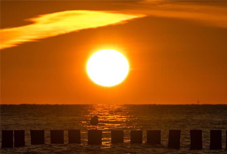 Sonne am Meer, Sonnenuntergang. Sonne, blauer Himmel und steigende Temperaturen: In Niedersachsen und im Land Bremen kündigt sich ein heißer Dienstag an – besonders im Landesinneren wird es sommerlich warm.