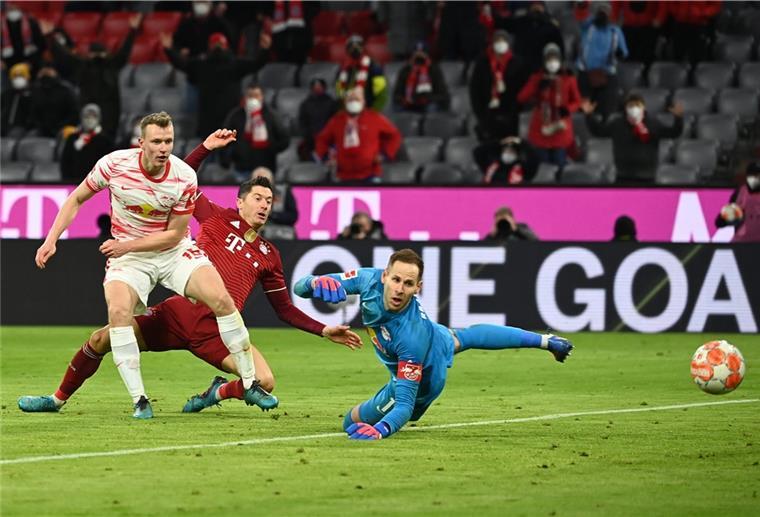 Spannend ist das Spiel zwischen Bayern München und RB Leipzig: Hier schaut Robert Lewandowski (Mitte) zusammen mit Leipzigs Lukas Klostermann (links) und Leipzigs Torhüter Peter Gulacsi seinem Schuss aufs Tor nach.