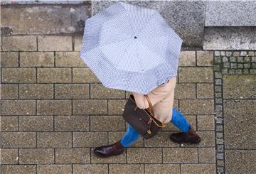 Eine Frau geht mit einem Regenschirm durch die Innenstadt.