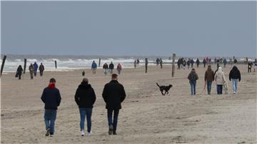 Spaziergänger am Strand der ostfriesischen Insel Norderney. 
