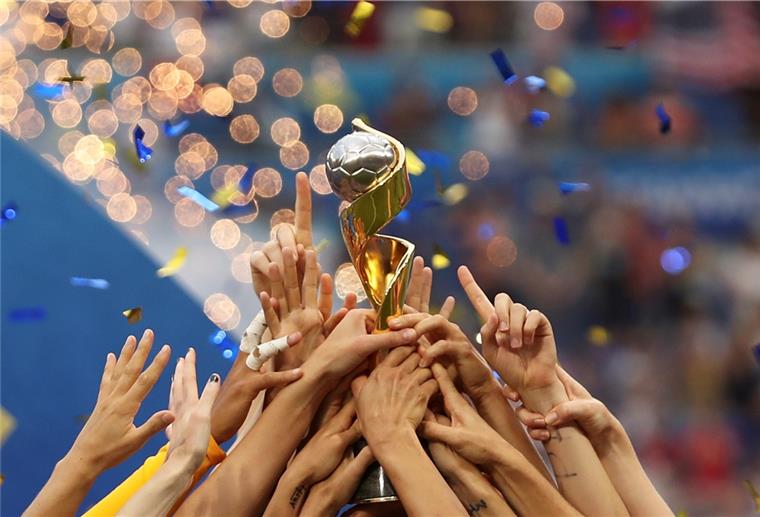 Spielerinnen des US-Teams stemmen 2019 gemeinsam die Trophäe in die Luft. Der Deutsche Fußball-Bund bewirbt sich zusammen mit Belgien und den Niederlanden um die Ausrichtung der Frauen-Weltmeisterschaft 2027.