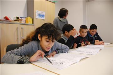 Sprache als Basis (von links): Zainab (12), Mustafa (10), Mohamad (9) und Lewin (15) lernen mit der pensionierten Lehrerin Veronika Nass.  Foto Fixy 
