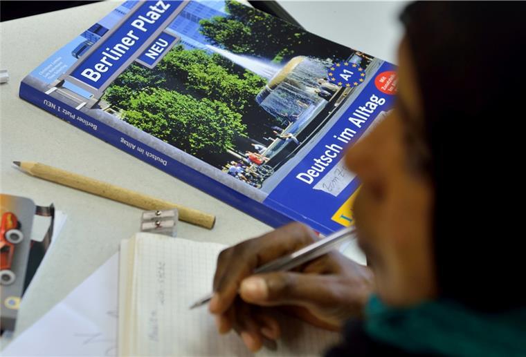 Flüchtlingsarbeit in Schiffdorf: Wohnraum und Helfer gesucht Das Lehrbuch "Deutsch im Alltag" liegt in einem Deutschkurs für Flüchtlinge vor einer jungen Frau auf der Schulbank.