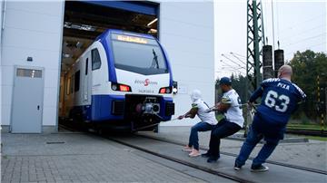 Stark: Die Seahawks-Footballer Kadeem Pankey, Martin Köhnken und Falk Pixa (von links) ziehen einen Triebwagen der Nordwestbahn aus der Garage.
