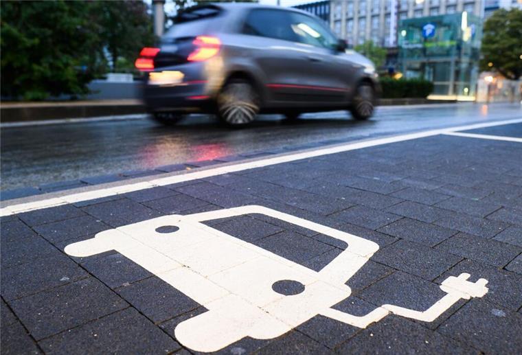 Ein Symbol markiert einen Parkplatz an einer Ladesäule für Elektroautos.