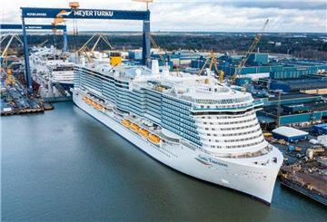 Das Kreuzfahrtschiff „Costa Toscana“ liegt fertiggestellt an der Werft Meyer Turku in Finnland. Im Hintergrund sind Werftanlagen, Hallen und Kräne zu sehen.
