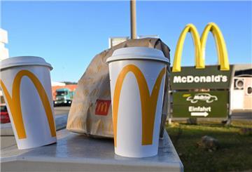 Eine McDonald's To-Go-Tüte und ein To-Go-Becher stehen vor einer Tübinger McDonald's-Filiale.