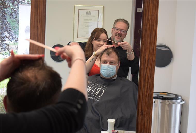 Stefan Hartmann (hinten), Inhaber des Friseursalons „Haarscharf“ in Hagen, ist zufrieden mit der Arbeit seiner Auszubildenden Leeann Köster, die sich gerade um den Haarschnitt von Nick Mehrtens kümmert.
