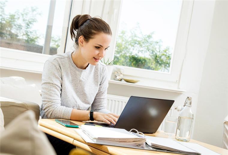 Eine Frau sitzt am Laptop.