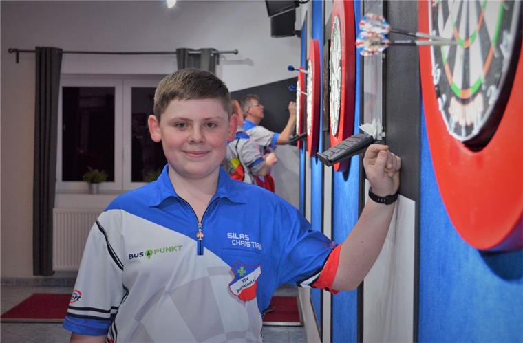 Stolz präsentiert Silas Christiani aus Hagen-Uthlede seinen Super-Wurf: Mit der Triple 19 hat er Deutschlands besten Darts-Profi Max Hopp geschlagen.