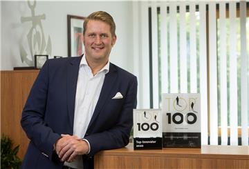 Stolz präsentiert Torben Möller, Geschäftsführer des Berufsbildungswerks Bremen, die Auszeichnung zum Top 100-Unternehmen.