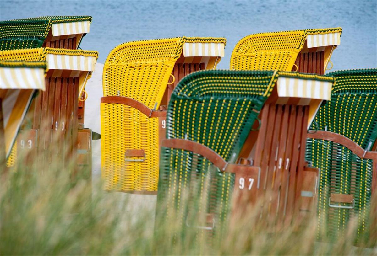 Strandkörbe stehen bei sonnigem Wetter am Strand auf der Insel Rügen.
