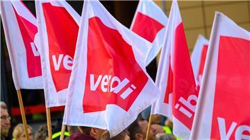 Streikende stehen mit Verdi-Fahnen.