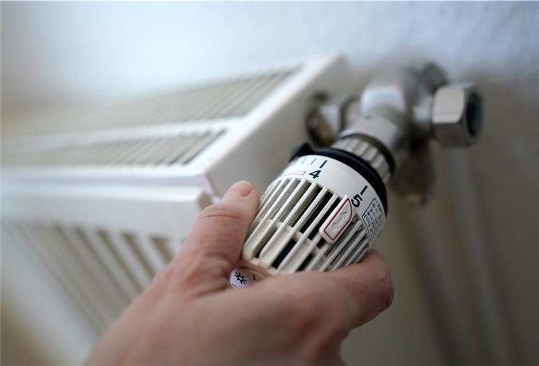 Eine Frau dreht an einem Heizungsthermostat. Die steigenden Energiekosten bereiten vielen Haushalten Sorge.