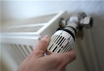 Eine Frau dreht an einem Heizungsthermostat. Die steigenden Energiekosten bereiten vielen Haushalten Sorge.