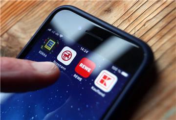 Ein Finger tippt auf einen Bildschirm mit verschiedenen Apps.