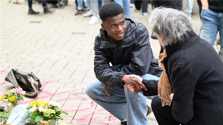 Trauer, Wut und große Demo nach tödlichen Polizeischüssen Suraj Mailitafi (l) von der Initiative „Gerechtigkeit für Lorenz“ spricht mit einer Passantin an dem Ort, an dem der 21-Jährige von der Polizei erschossen wurde.