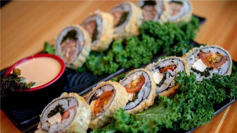 Sushi mit Grünkohl, Tomaten und Feta (vorne) sowie Sushi mit Grünkohl und Pinkel steht im Restaurant Moto Kitchen auf einem Tisch.