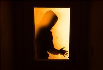 Symbolbild: Der Schatten eines Mannes ist hinter einer gläsernen Wohnungstür zu sehen.