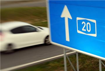 Symbolbild: Ein Auto fährt an einem Schild vorbei, das auf die A20 verweist. Foto: dpa