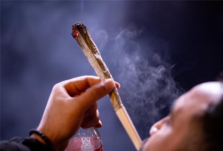 Auch nach Cannabis-Legalisierung: An diesen Orten ist der Konsum verboten Eine Person raucht einen übergroßen Joint.