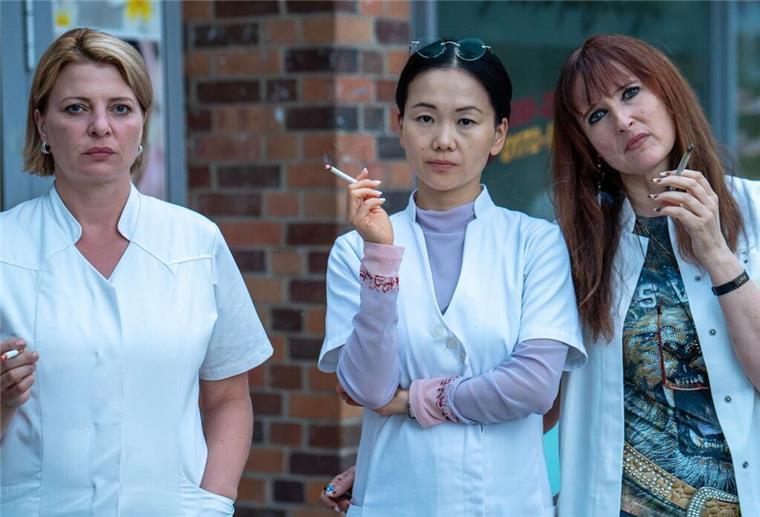 TV stets reich: Wo bleibt die Sozialkritik in Serien? Szene aus der Serie „Marzahn Mon Amour“: Kathi Grabowski (Jördis Triebel), ihre Chefin Jenny Chan (Yvonne Yung Hee Bormann) und Kollegin Lulu Moll (Deborah Kaufmann). (Undatiertes Handout).