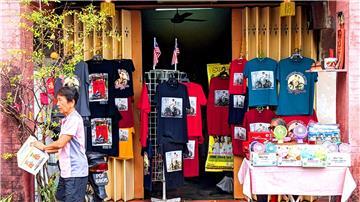 T-Shirts und andere Dinge, auf denen Street Art-Kunstwerke aus Penang abgebildet sind, werden in einem Geschäft zum Kauf angeboten.