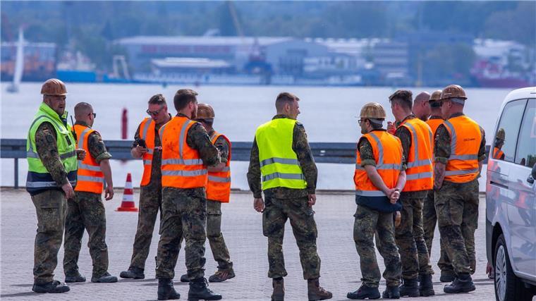 Teilnehmer der Übung National Guardian 24 der Bundeswehr warten im Seehafen auf die verspätete Ankunft eines Transportzugs mit Panzern.