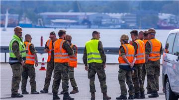 Teilnehmer der Übung National Guardian 24 der Bundeswehr warten im Seehafen auf die verspätete Ankunft eines Transportzugs mit Panzern.