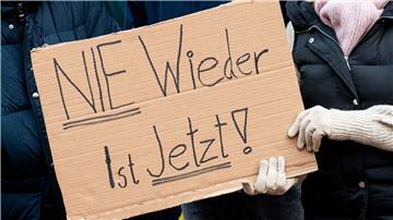 Teilnehmer einer Demonstration gegen Rechtsextremismus halten ein Schild in den Händen.