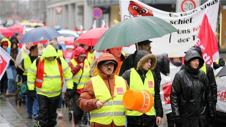 Schlangen vor Weihnachten: Warnstreik im Einzelhandel Teilnehmer einer Verdi-Kundgebung gehen mit Plakaten durch die Innenstadt.