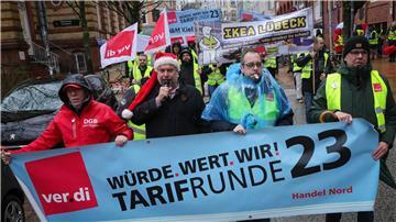 Teilnehmerinnen und Teilnehmer eines Warnstreiks ziehen mit Fahnen der Gewerkschaft Verdi durch die Stadt.
