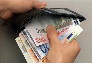 Ein Mann verstaut einige Euro-Geldscheine in seiner Geldbörse. Seit 1. Mai gelten neue Regeln für Elterngeld und Elternzeit.