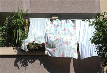 Mit Tüchern schützen Bewohner die Pflanzen auf dem Balkon und ihre Wohnung vor der heißen Sonne.