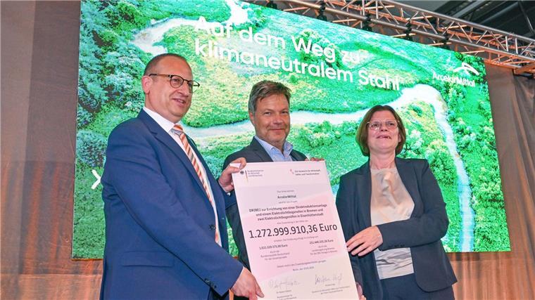 Habeck sieht Stahlstandorte für Zukunft gerüstet Thomas Bünger (l-r), CEO von ArcelorMittal, Robert Habeck (Grüne), Bundeswirtschaftsminister und Kristina Vogt (Die Linke), Bremer Senatorin für Wirtschaft, zeigen einen Fördermittelbescheid.