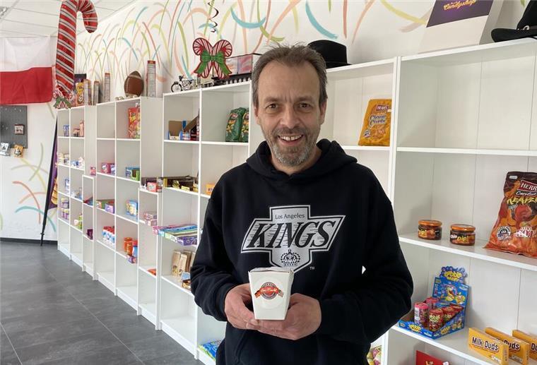 Ein Mann steht in einem Laden und hält eine Packung Eis in der Hand.