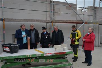 Thorsten Krüger (von links) musste mit dem Hammer ein wenig nachhelfen, um die Zeitkapsel zu verschließen. Gemeinsam mit Günter Diekhoff, Fabian Koop, Peter Steffens, Michael Rinas und Ellen Frank verbaute er das Gefäß anschließend im Mauerwerk des neuen Feuerwehrhauses.