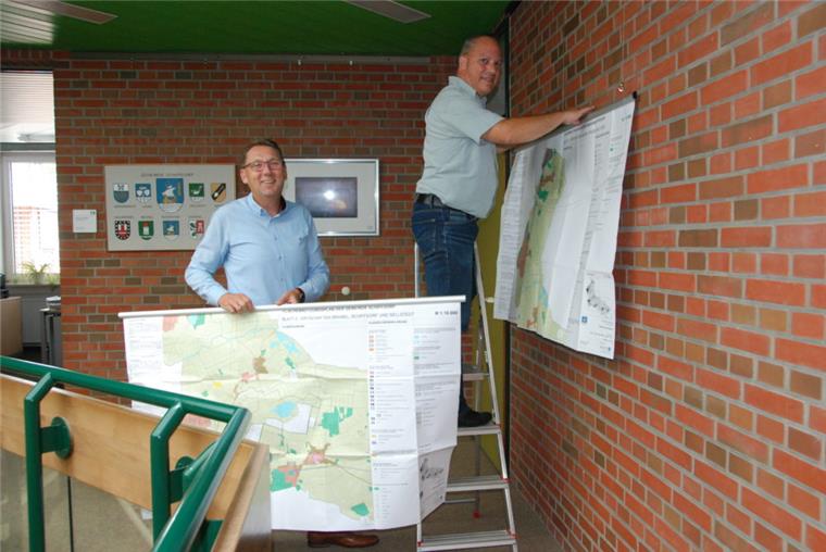 Thorsten Küver (links) und Stephan Grün haben die Zukunftspläne für die sieben Ortschaften der Gemeinde Schiffdorf am Mittwoch aufgehängt, so dass die Bürger sie ab sofort unter die Lupe nehmen können.