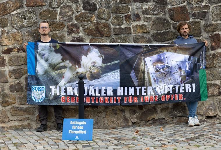 Tierschutzaktivisten stehen mit einem Transparent mit der Aufschrift "Tierquäler hinter Gitter! Gerechtigkeit für ihre Opfer." vor dem Amtsgericht Bad Iburg.