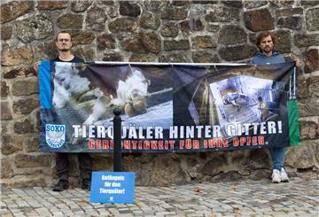 Tierschutzaktivisten stehen mit einem Transparent mit der Aufschrift "Tierquäler hinter Gitter! Gerechtigkeit für ihre Opfer." vor dem Amtsgericht Bad Iburg.