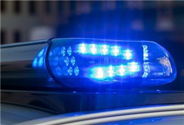 Das Blaulicht auf einem Fahrzeug der Polizei leuchtet in der Dunkelheit.