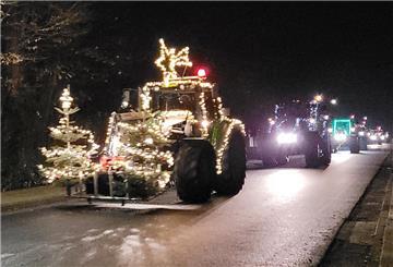 Ein Trecker fährt mit Lichtern durch die Straße.