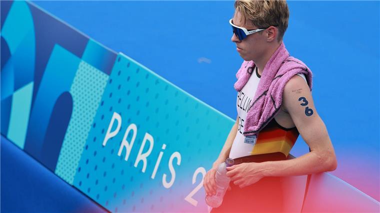 Triathlet Tim Hellwig lehnt nach dem Olympia-Rennen enttäuscht an einer Bande.