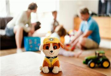 Ein Kinderspielzeug und im Hintergrund eine Familie. 