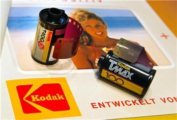 Zwei Schwarz-Weiss-Kodakfilme liegen nebeneinander auf einer Zeitungsanzeige von Kodak.