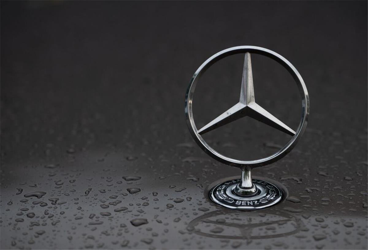 Sparhammer bei Daimler Truck: Tausende Mitarbeiter müssen um Job bangen Regentropfen sind auf einem Mercedes-Stern auf einem Fahrzeug zu sehen.