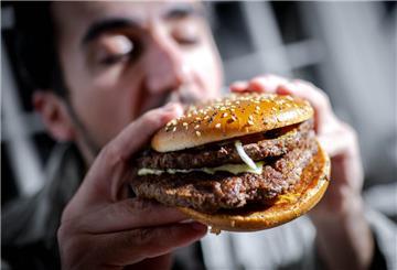  Mann beißt in einen Burger. 