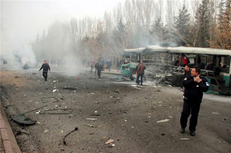 Terror in der Türkei: 13 Soldaten bei Anschlag getötet - Dutzende Verletzte Türkische Polizisten inspizieren nach der Explosion einer Autobombe den Tatort vor der Erciyes-Universität im zentraltürkischen Kayseri.