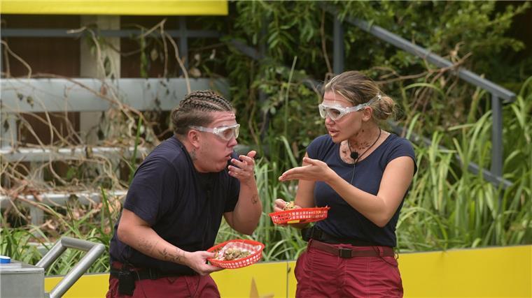 Twenty4Tim und Kim Virginia probieren einen Snack, bestehend aus Krokodilpenis, Innereien-Soße, Stinketofu-Senf, Kakerlaken-Bun und Röst-Maden-Zwiebeln.